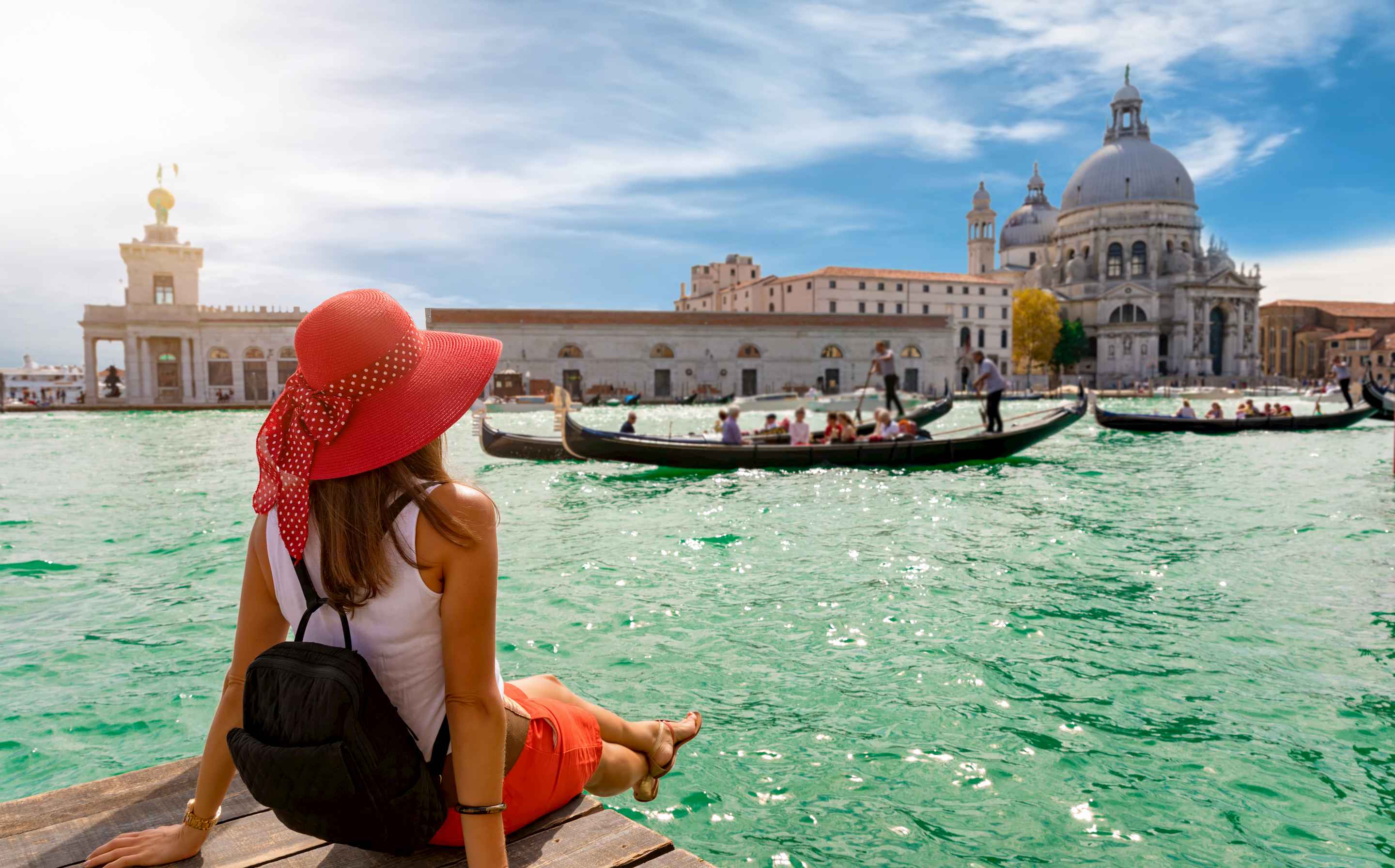 A woman looking across the canal in Venice at Santa Maria della Salute