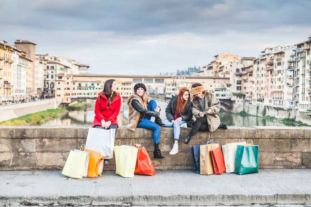Women sitting on a bridge after shopping in Florence